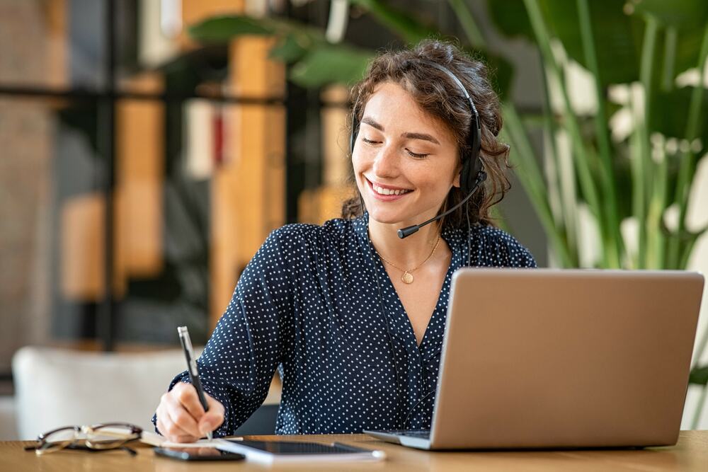 Erfolgreiche Frau telefoniert im Kundenservice mit Laptop im Büro